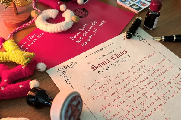 Handwritten Santa letter with its hand-addressed red envelope, the stamp and the Merry felt letters