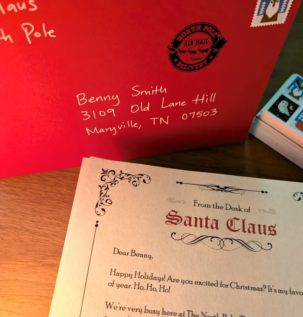 A printed letter from Santa on Santa Claus letterhead beside a hand-addressed red envelope with the North Pole Air Mail stamp