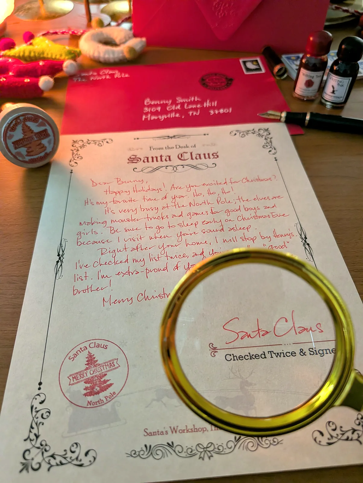 Santa's signature and North Pole stamp under a magnifying glass in warm light
