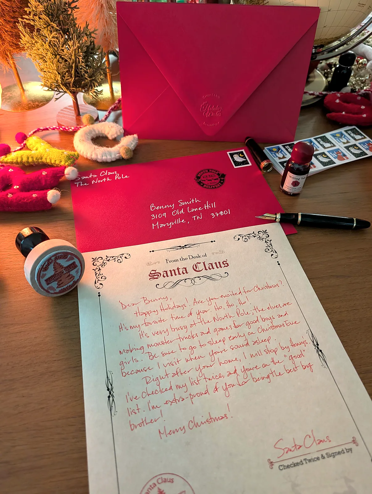 Handwritten Santa letter with its hand-addressed red envelope, real stamps and the fountain pen